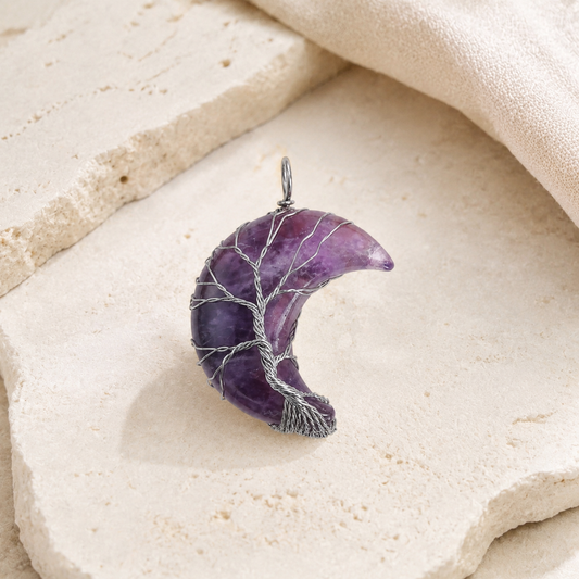 Amethyst Moon Tree of Life Necklace on a warm ivory stone surface.
