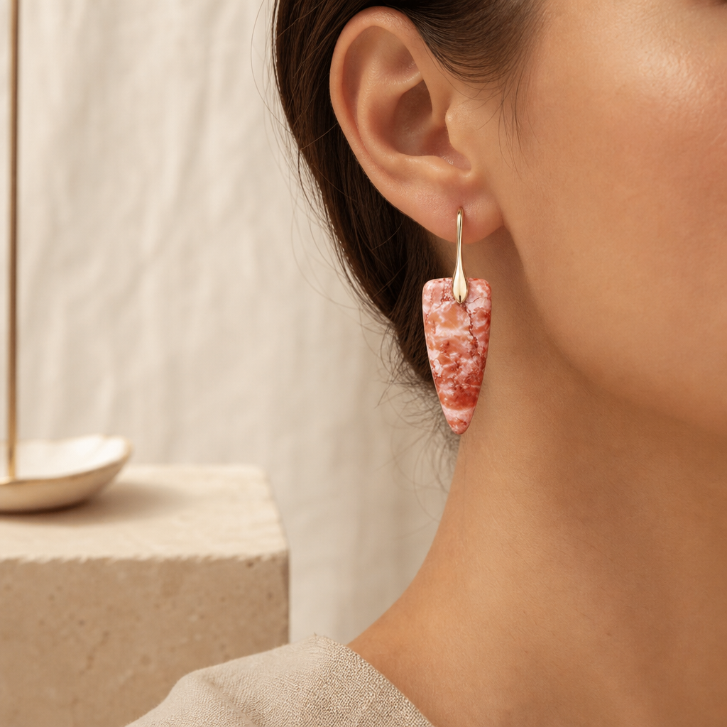 Gold coral natural stone geometric earrings worn as a light drop earring.