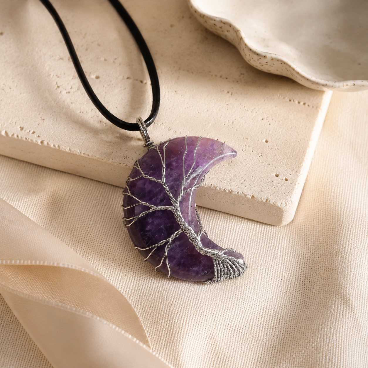 Gift-ready amethyst moon pendant necklace on warm linen.